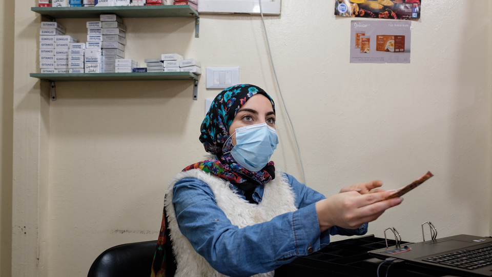 Nour, 26, works at the cash register and assists customers. She says that other store owners were frustrated at first when the co-op opened. April 16, 2021. (Rita Kabalan/The Public Source)